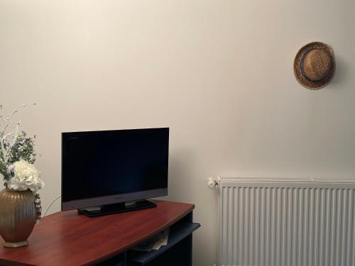 a flat screen tv sitting on top of a wooden table at Un studio dans la résidence SJT in Alençon