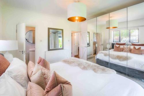 1 dormitorio grande con 2 camas y espejo en Luxury Goodwood home, Hot tub, 3 Bedrooms, Pet Friendly, en Chichester