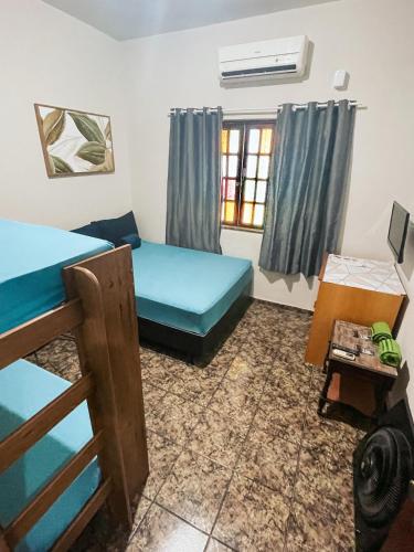 a room with two bunk beds and a window at Pousada Califor in Nova Iguaçu