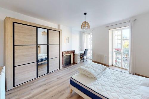 a white bedroom with a bed and a desk in it at Appartement Lafayette N°3 in Bagnères-de-Bigorre