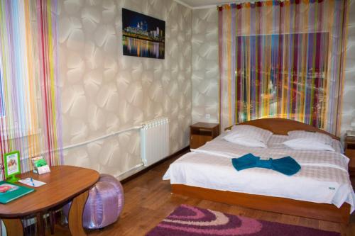 um quarto com uma cama com uma gravata borboleta azul em Сити em Petropavl