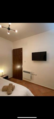 a bedroom with a bed and a flat screen tv at Delfi's cozy maisonette in Delfoi