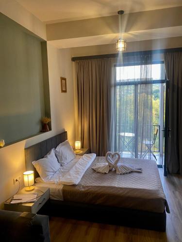 a bedroom with a large bed with a large window at Apartment #102 in aparthotel in Tsaghkadzor