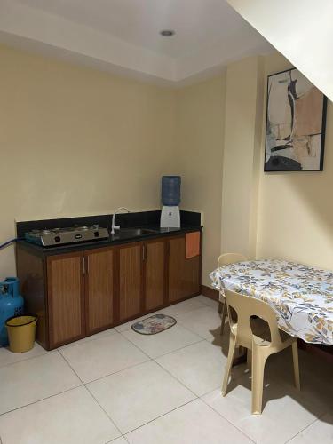 - une cuisine avec une table, un évier, une table et des chaises dans l'établissement JMC Residence 3, à Tagbilaran