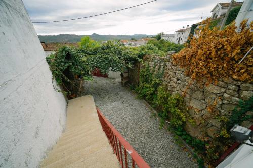 a stone wall with a wooden staircase next to a building at Alijo Vintage House in Alijó