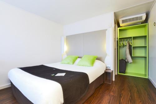- une chambre avec un grand lit et des étagères vertes dans l'établissement Campanile Béziers A9/A75, à Béziers