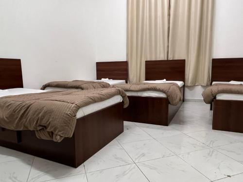 two beds sitting in a room with at Short Stay Apartment in Dubai
