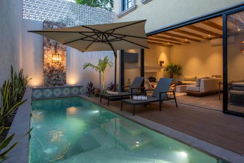 a swimming pool with an umbrella and a patio at Hermosa villa de 3 habitaciones en el corazón de San Miguel de Allende, Casa Suspiros in San Miguel de Allende