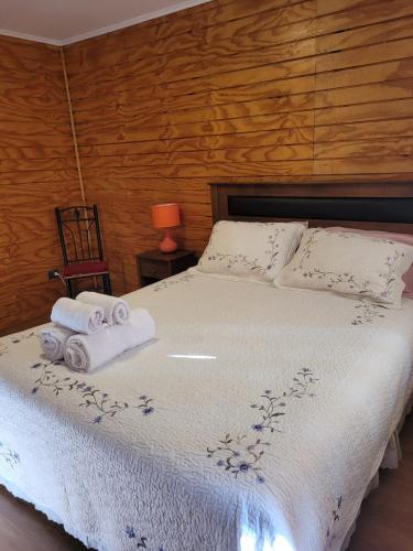1 dormitorio con 1 cama con toallas en Cabañas ali en Puerto Aisén