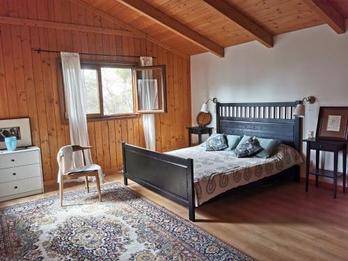 a bedroom with a bed and a chair and a window at Landscape Casa de Madera in Tarragona