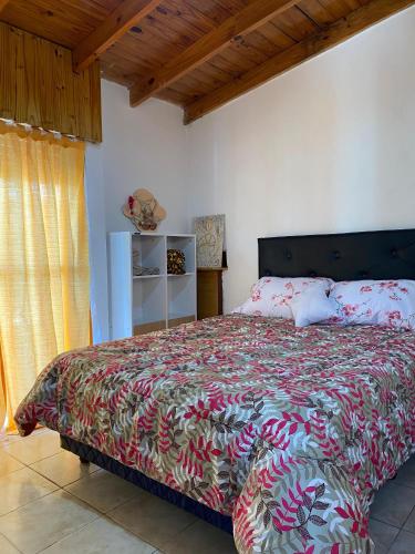 1 dormitorio con 1 cama con colcha colorida en La casita de Greis en La Unión