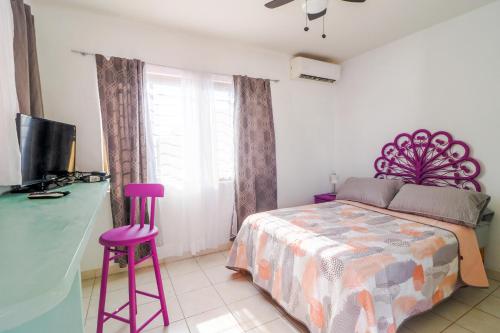 um quarto com uma cama e dois bancos roxos em Habitación Privada en Zona Dorada em Mazatlán