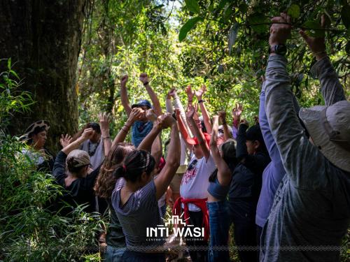 Une foule de gens avec les mains en l'air dans l'établissement Centro Turístico Inti Wasi, à Saraguro