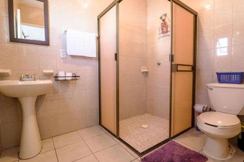 uma casa de banho com um chuveiro, um WC e um lavatório. em Habitación Privada en Zona Dorada em Mazatlán