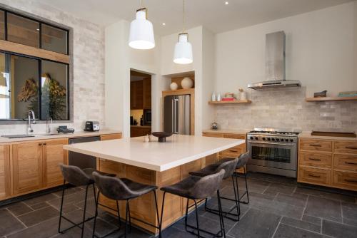 a kitchen with a large island with bar stools at Hermosa villa de 3 habitaciones en el corazón de San Miguel de Allende, Casa Suspiros in San Miguel de Allende