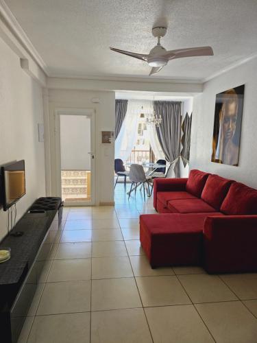 - un salon avec un canapé rouge et une télévision dans l'établissement Sunny apartament near La Mata beach, à Torrevieja