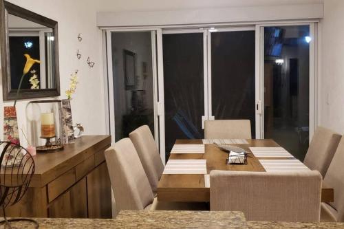 a dining room with a wooden table and chairs at Casa entera Alberca en Acapulco Diamante in Acapulco