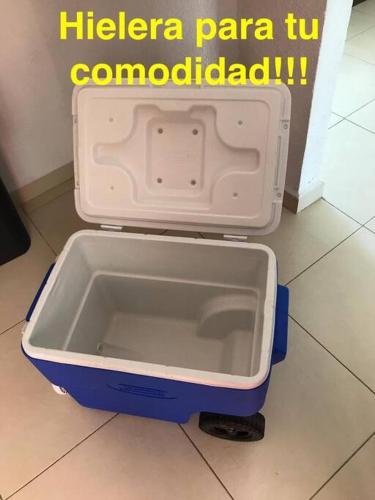 a plastic container is sitting on the floor next to a refrigerator at Casa entera Alberca en Acapulco Diamante in Acapulco