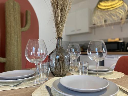 - une table avec des verres à vin, des assiettes et un vase dans l'établissement Le Mexico - hyper centre & parking, à Montaigu-Vendée