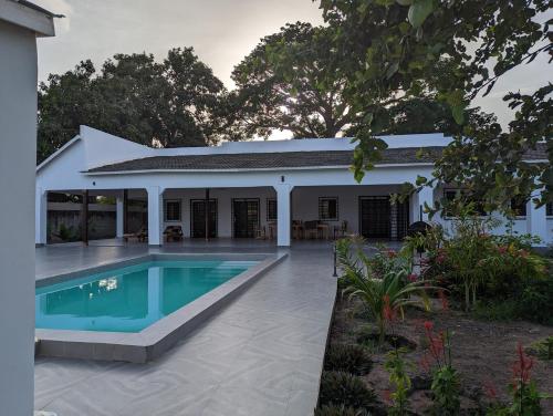 een afbeelding van een huis met een zwembad bij Flower Garden House in Sanyang