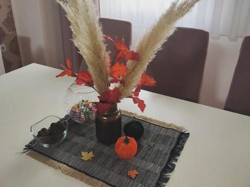 a vase with pumpkins and decorations on a table at Apartman Jana in Bijeljina