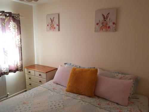 a bedroom with a bed with pink and orange pillows at Double Bedroom in Crewe With Shared Kitchen and Bath in Crewe