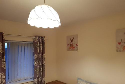 a living room with a chandelier and a window at Double Bedroom in Crewe With Shared Kitchen and Bath in Crewe