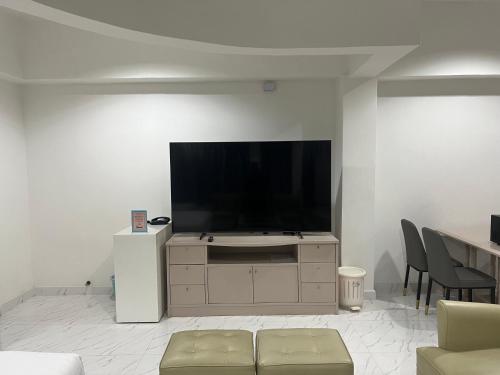 a living room with a flat screen tv on a white wall at Mall Suites Hotel in Bangkok