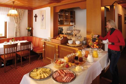a woman standing in front of a table with food at Hotel Sonnalpen in Damuls