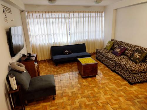 una sala de estar con un sofá y una silla en Antarki Apartment, en Cusco
