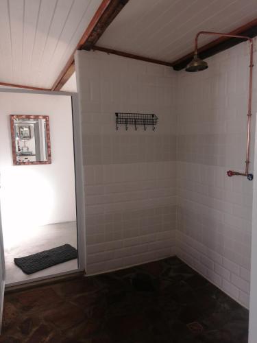 a bathroom with white tiled walls and a mirror at Lank-gewag Farm Cottage with private hottub in Montagu