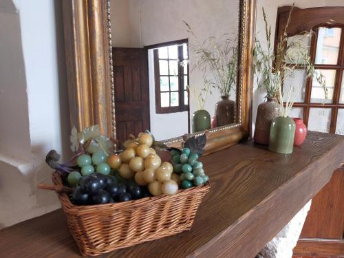 a basket of fruit on a table in front of a mirror at L'Imprévu de Cotignac, Appart' et Duplex au cœur du village in Cotignac