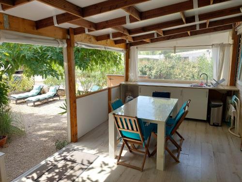 une cuisine avec une table et des chaises sur une terrasse dans l'établissement Mobil-home bord de mer Hyères, à Hyères