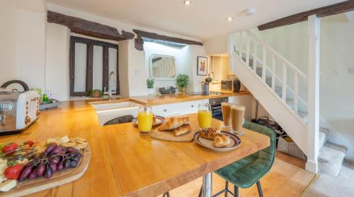 a kitchen with a wooden table with food on it at Wee Toad Hole Heart of Kendal - Cottage sleeps 4-6 - Dogs Welcome in Kendal