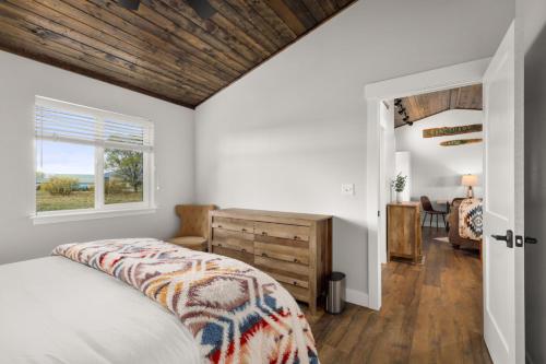1 dormitorio con paredes blancas y techo de madera en The Kabins en Columbia Falls
