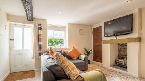 een woonkamer met een grijze bank en een open haard bij Wee Toad Hole Heart of Kendal - Cottage sleeps 4-6 - Dogs Welcome in Kendal