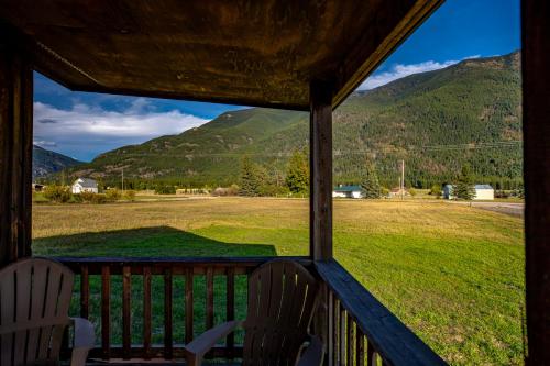 a porch with a view of a field and mountains at The Kabins in Columbia Falls
