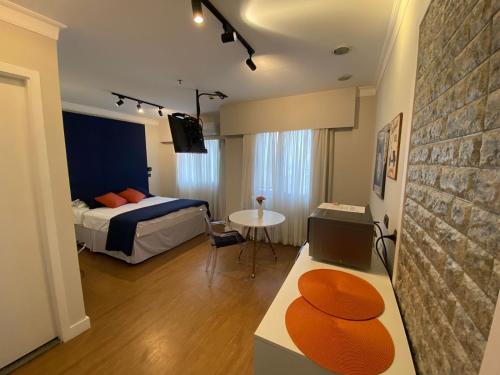une chambre avec un lit et une table dans une pièce dans l'établissement Flat Funcional em frente ao Aeroporto de Congonhas, à São Paulo