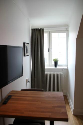 a room with a table and a television and a window at Continental Apartment Hotel Sundsvall in Sundsvall
