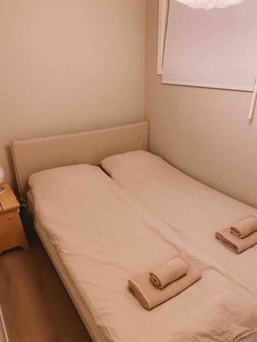 a small room with two beds with towels on them at Cute little appartment in Kristiansand