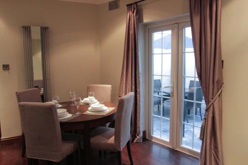 a dining room with a table and chairs and a window at Paddington Patio Apartment in London