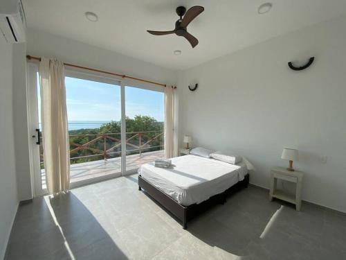 een slaapkamer met een bed en een groot raam bij Casa el Susurro - Barranquilla, Tubará in Tubará