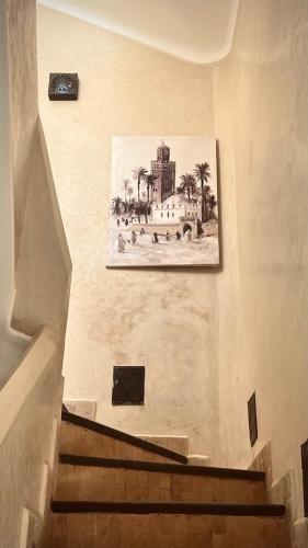 a picture of a painting on a wall next to stairs at Riad des Fragrances dar el Bacha in Marrakech