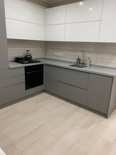 a kitchen with a sink and a stove top oven at Zoe’s cozy apartment in Chişinău