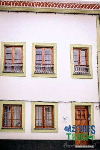 a white building with windows and a sign on it at Atlântida Dream T1 in Angra do Heroísmo