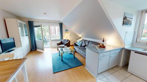 uma sala de estar com um sofá e uma televisão em Deich-Residenz App. 6 em Grömitz