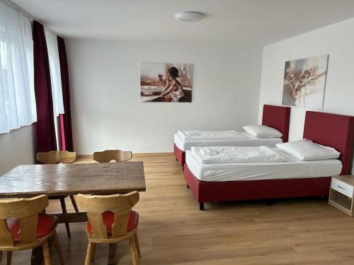 Pokój z 2 łóżkami, stołem i krzesłami w obiekcie Othman Appartements Alte Schmiede 22 w Hanowerze