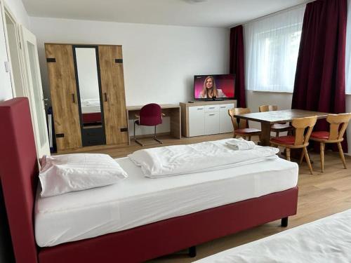a hotel room with two beds and a table and a television at Othman Appartements Alte Schmiede 22 in Hannover