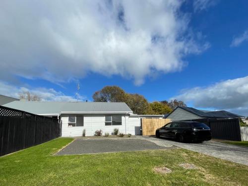 a house with a car parked in the driveway at Perfect On The Park in Tauranga