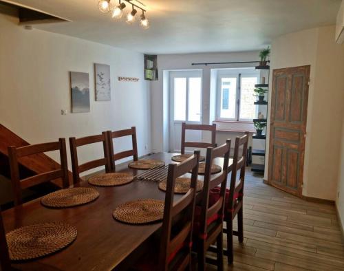 a dining room with a wooden table and chairs at Maison au cœur du Revermont in Ménétru-le-Vignoble